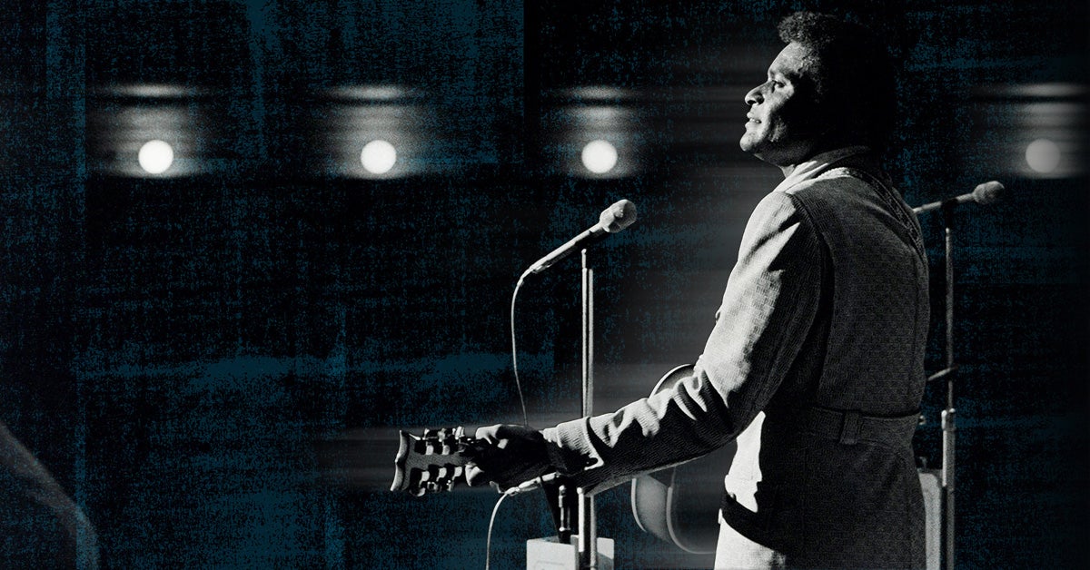 Photo of Charley Pride playing on stage at the Ryman