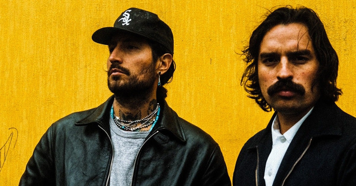 Brothers Alejandro and Estevan Gutiérrez pose in front of a yellow backdrop. 