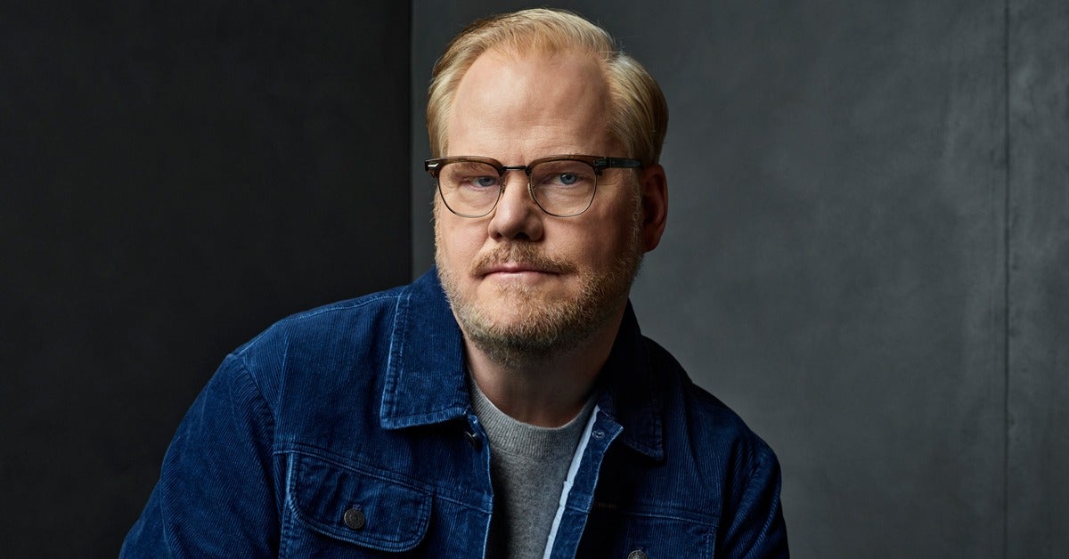 Photo portrait of Jim Gaffigan posing in front of a backdrop
